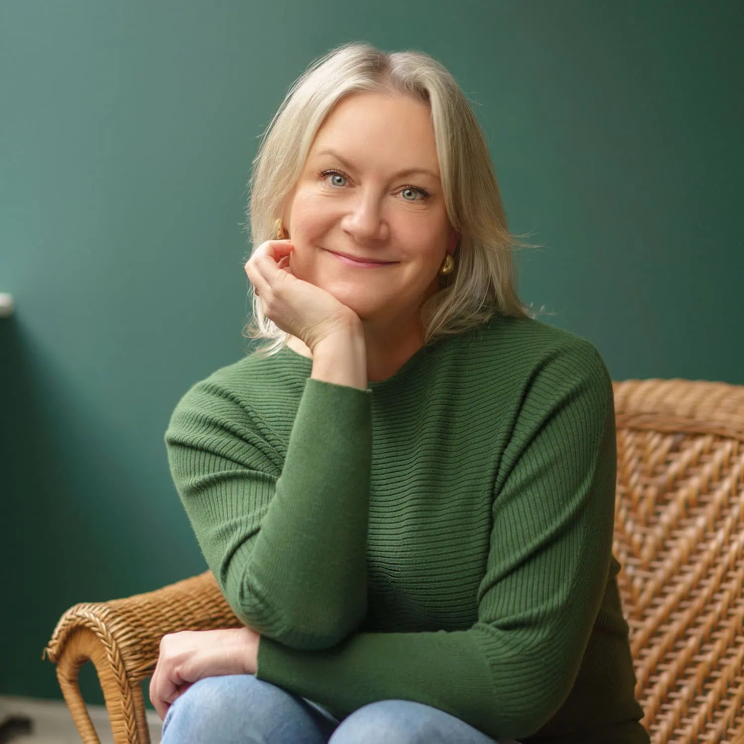 portrait of counsellor kerry anne holoway sitting down in a green room smiling at the camera